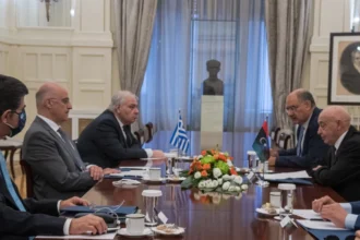 Ο Αγκίλα Σάλεχ και η λιβυκή αντιπροσωπεία απέναντι από την ελληνική αντιπροσωπεία με τον Νίκο Δένδια, με ελληνική και λιβυκή σημαία στο τραπέζι
