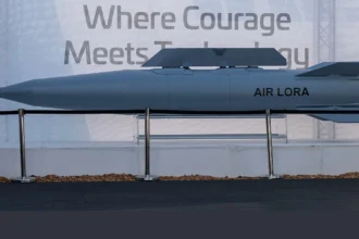 Γκρι βαλλιστικός πύραυλος με την επιγραφή AIR LORA εκτεθειμένος σε βάση πίσω από κορδόνι