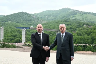 Ο Ιλχάμ Αλίγιεφ και ο Ρετζέπ Ταγίπ Ερντογάν δίνουν τα χέρια μπροστά σε γέφυρα αυτοκινητόδρομου σε ορεινή περιοχή