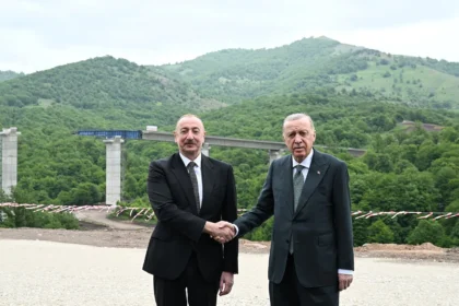 Ο Ιλχάμ Αλίγιεφ και ο Ρετζέπ Ταγίπ Ερντογάν δίνουν τα χέρια μπροστά σε γέφυρα αυτοκινητόδρομου σε ορεινή περιοχή
