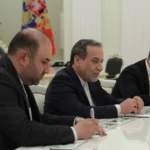 Ο Αμπάς Αραγτσί με σκούρο κοστούμι κάθεται σε τραπέζι συνομιλιών ανάμεσα σε μέλη αντιπροσωπείας