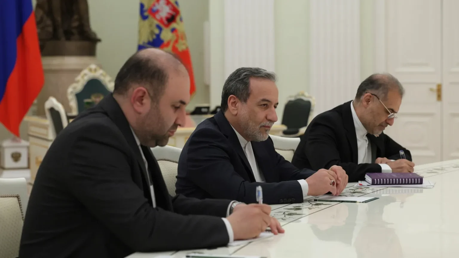 Ο Αμπάς Αραγτσί με σκούρο κοστούμι κάθεται σε τραπέζι συνομιλιών ανάμεσα σε μέλη αντιπροσωπείας