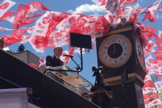 Ο Ντεβλέτ Μπαχτσελί μιλά από εξέδρα με ρολόι, ανάμεσα σε σημαιάκια του MHP, σε συγκέντρωση στην Άγκυρα