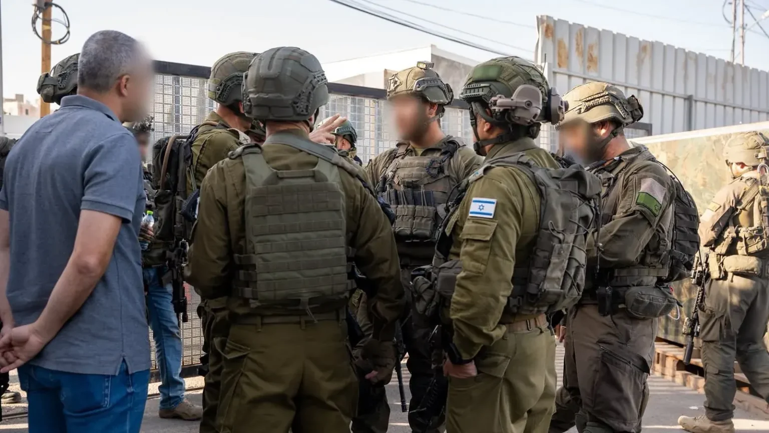 Ισραηλινοί στρατιώτες με πλήρη εξάρτυση συσκέπτονται σε δρόμο κατά την επιχείρηση στην περιοχή της Χεβρώνας