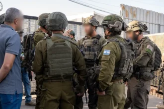Ισραηλινοί στρατιώτες με πλήρη εξάρτυση συσκέπτονται σε δρόμο κατά την επιχείρηση στην περιοχή της Χεβρώνας