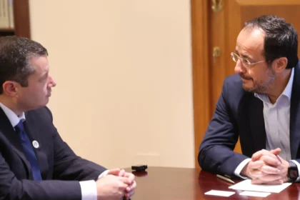 Ο Νίκος Χριστοδουλίδης σε συνάντηση στο Προεδρικό Μέγαρο, καθισμένος σε ξύλινο τραπέζι