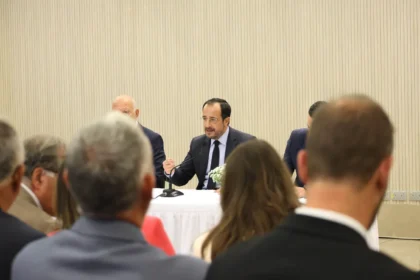 Ο Πρόεδρος της Κύπρου Νίκος Χριστοδουλίδης μιλά σε τραπέζι με μικρόφωνο, με ακροατές σε πρώτο πλάνο