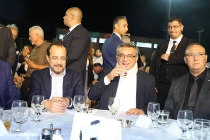 Ο Νίκος Χριστοδουλίδης και ο Τουφάν Έρχιουρμαν κάθονται στο ίδιο τραπέζι σε υπαίθρια εκδήλωση με άλλους καλεσμένους