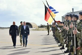 Ο Νίκος Δένδιας και ο Μπόρις Πιστόριους περπατούν δίπλα σε τιμητικό άγημα με τις σημαίες Ελλάδας και Γερμανίας σε αεροδρόμιο