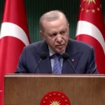 Ο Ρετζέπ Ταγίπ Ερντογάν μιλά από βήμα με τουρκικές σημαίες μετά τη συνεδρίαση του υπουργικού συμβουλίου στην Άγκυρα