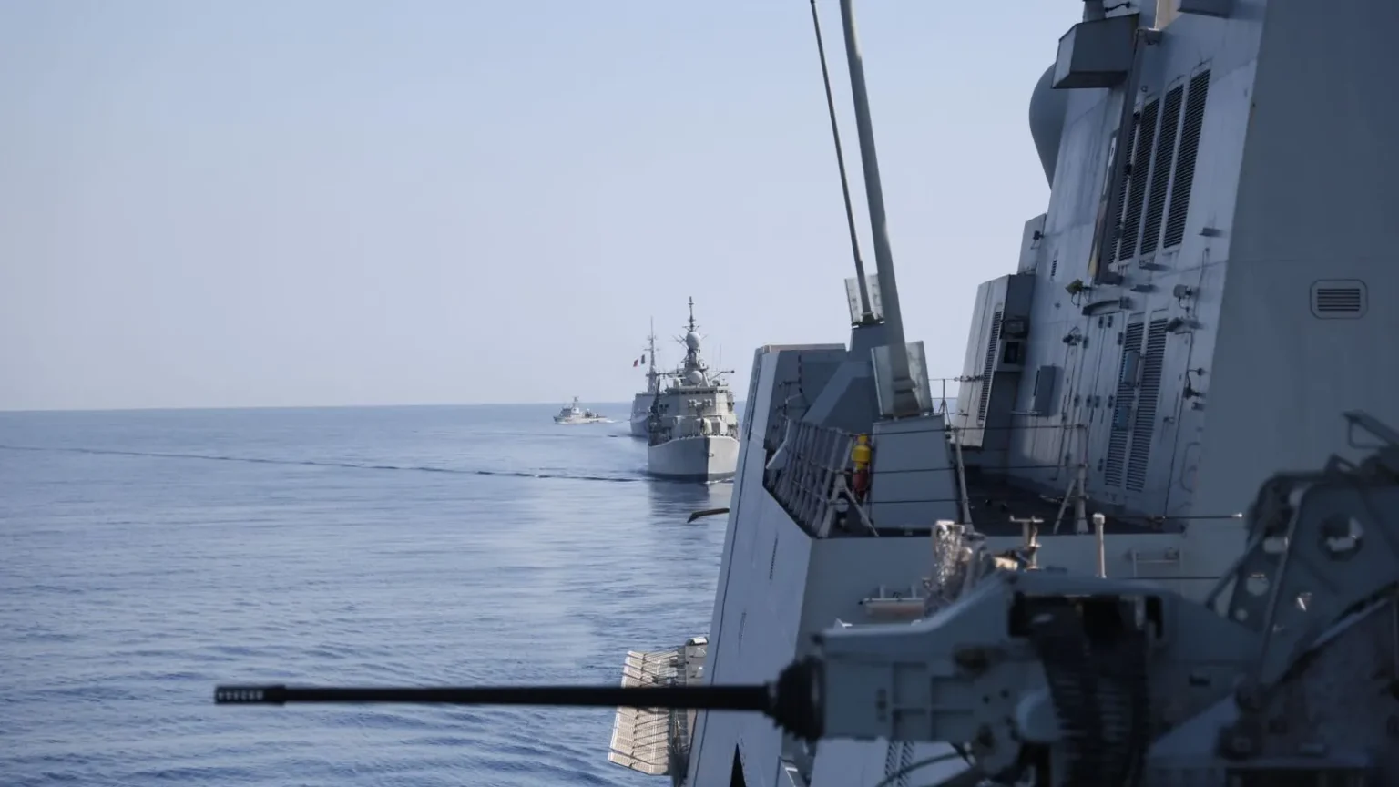 Πολεμικά πλοία πλέουν σε φάλαγγα στην Ανατολική Μεσόγειο κατά την άσκηση EUNOMIA 7-26, με πυροβόλο πλοίου σε πρώτο πλάνο