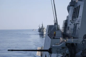 Πολεμικά πλοία πλέουν σε φάλαγγα στην Ανατολική Μεσόγειο κατά την άσκηση EUNOMIA 7-26, με πυροβόλο πλοίου σε πρώτο πλάνο
