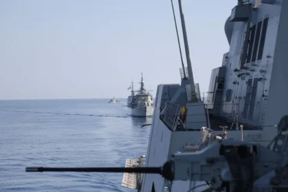 Πολεμικά πλοία πλέουν σε φάλαγγα στην Ανατολική Μεσόγειο κατά την άσκηση EUNOMIA 7-26, με πυροβόλο πλοίου σε πρώτο πλάνο
