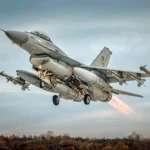 Γκρι μαχητικό F-16 απογειώνεται με πυραύλους στα άκρα των πτερύγων