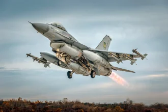 Γκρι μαχητικό F-16 απογειώνεται με πυραύλους στα άκρα των πτερύγων