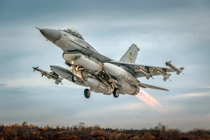 Γκρι μαχητικό F-16 απογειώνεται με πυραύλους στα άκρα των πτερύγων