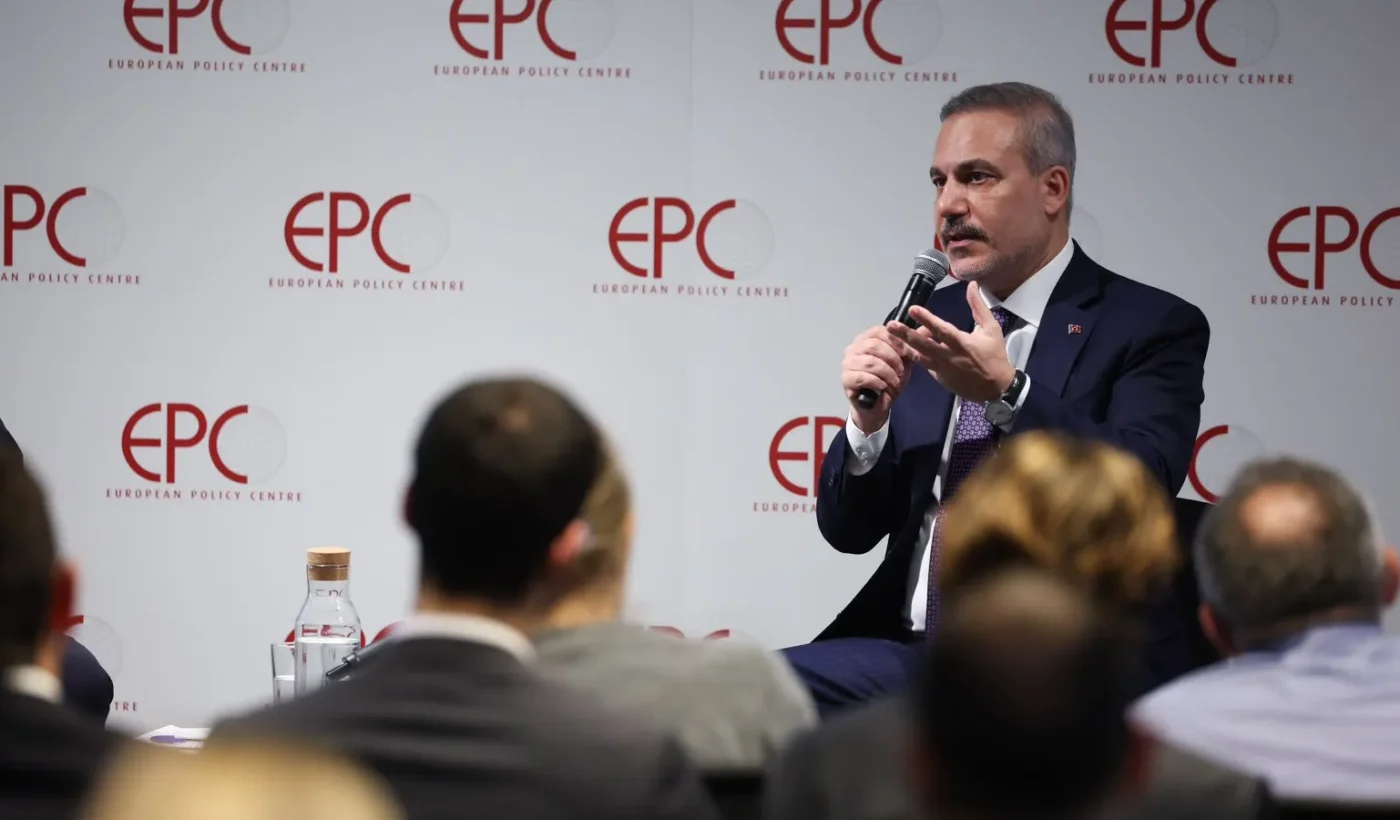 Ο Τούρκος υπουργός Εξωτερικών Χακάν Φιντάν μιλά με μικρόφωνο στο χέρι μπροστά από τοίχο με το λογότυπο EPC, ενώ στο πρώτο πλάνο φαίνεται το κοινό