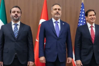Ο Χακάν Φιντάν όρθιος ανάμεσα στον Σύρο υπουργό Εξωτερικών Ασαάντ αλ Σαϊμπάνι και τον Μάρκο Ρούμπιο, μπροστά σε σημαίες