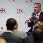 Ο Χακάν Φιντάν μιλά σε μικρόφωνο καθισμένος μπροστά σε πάνελ με το λογότυπο EPC, με κοινό σε πρώτο πλάνο