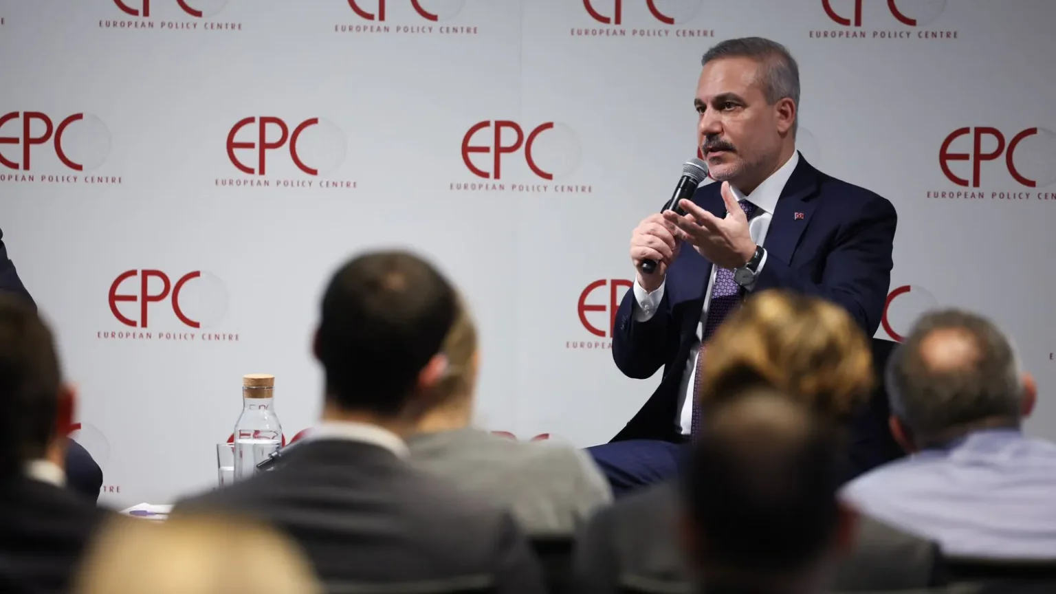 Ο Χακάν Φιντάν μιλά σε μικρόφωνο καθισμένος μπροστά σε πάνελ με το λογότυπο EPC, με κοινό σε πρώτο πλάνο