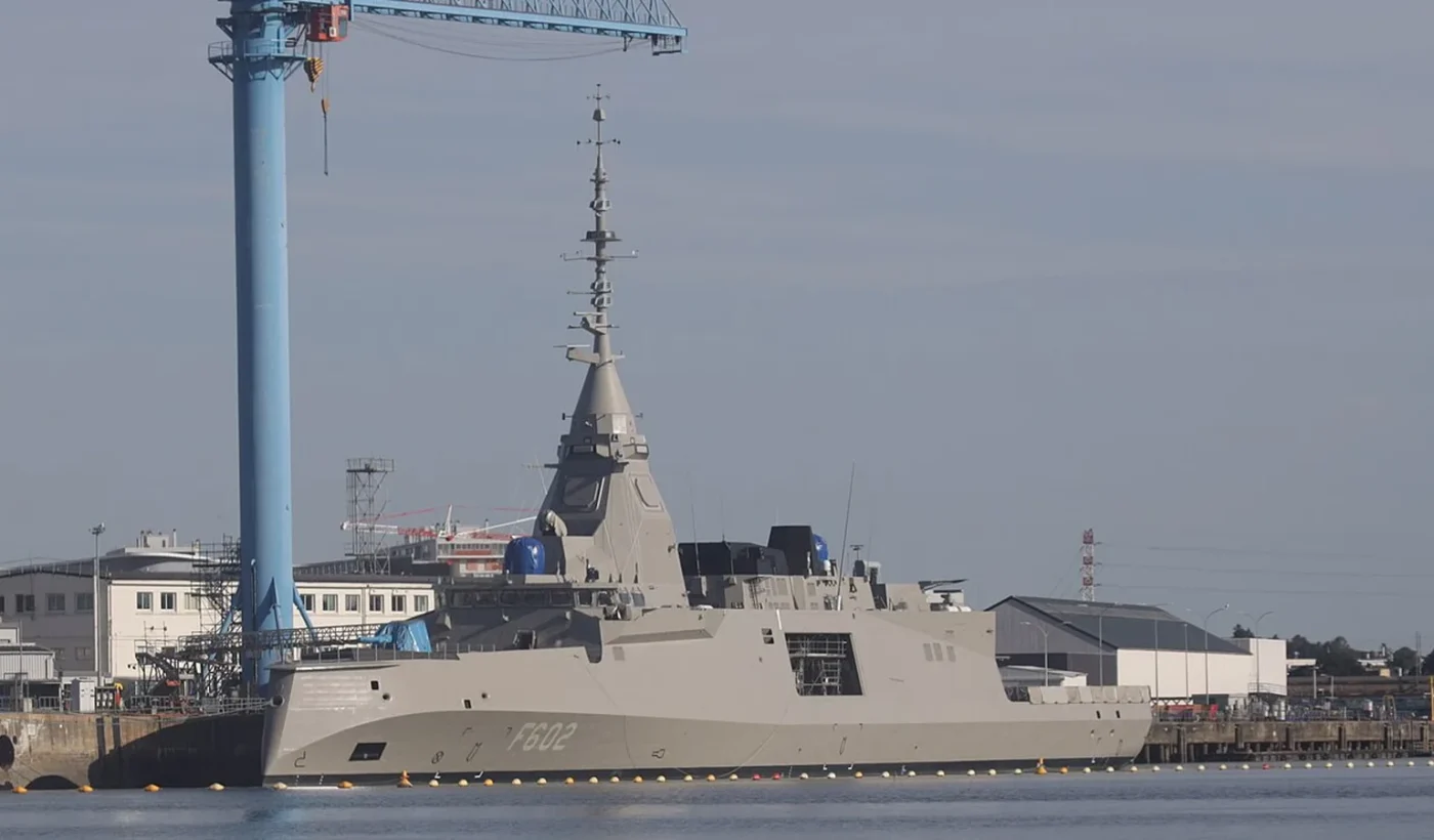 Η ελληνική φρεγάτα FDI F602 Νέαρχος δεμένη στη Λοριάν, με το ψηλό ιστό της να υψώνεται δίπλα σε γερανό της Naval Group