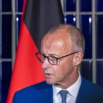 Ο Γερμανός καγκελάριος Φρίντριχ Μερτς μιλά μπροστά στη γερμανική σημαία