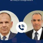 Κάρτα του υπουργείου Εξωτερικών με τα πορτρέτα του Γιώργου Γεραπετρίτη και του Μπαντρ Αμπντελάτι και εικονίδιο τηλεφώνου ανάμεσά τους