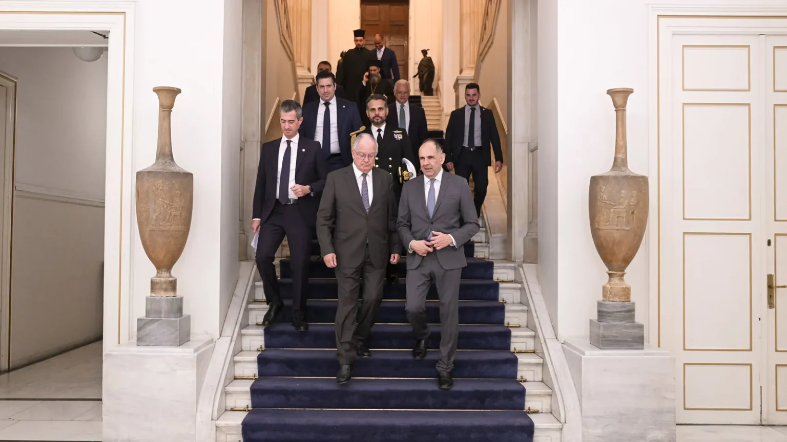 Ο υπουργός Εξωτερικών Γιώργος Γεραπετρίτης κατεβαίνει τη σκάλα του υπουργείου Εξωτερικών μαζί με άλλους αξιωματούχους