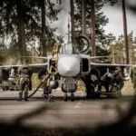 Σουηδοί τεχνικοί προετοιμάζουν μαχητικό Gripen σε δασώδη αεροπορική βάση