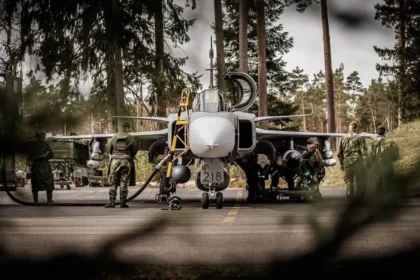 Σουηδοί τεχνικοί προετοιμάζουν μαχητικό Gripen σε δασώδη αεροπορική βάση