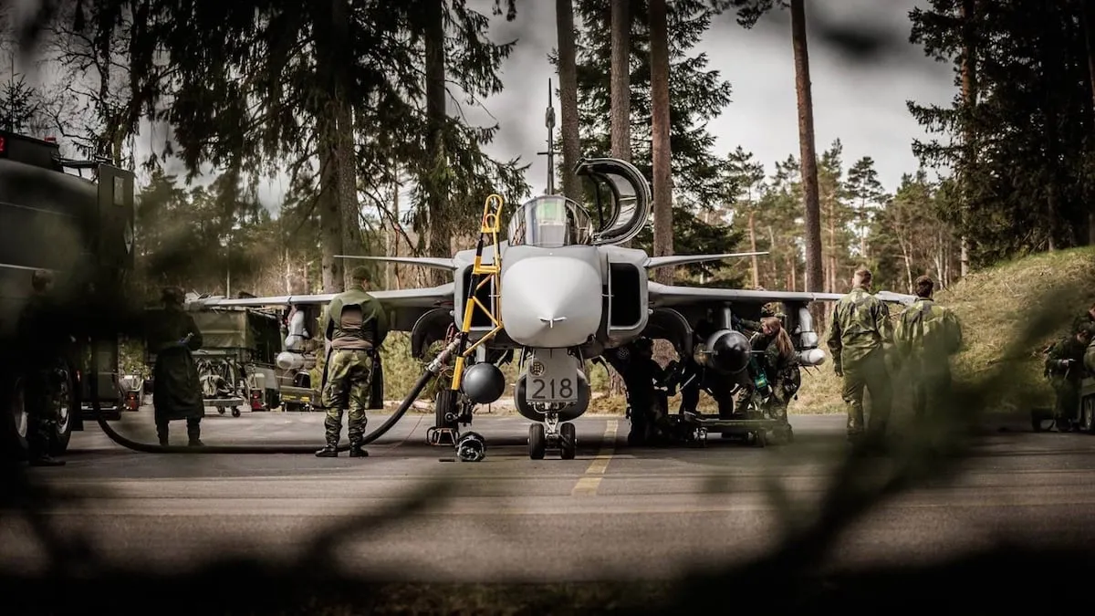 Σουηδοί τεχνικοί προετοιμάζουν μαχητικό Gripen σε δασώδη αεροπορική βάση