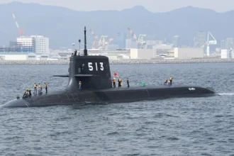 Το μαύρο ιαπωνικό υποβρύχιο Taigei πλέει στην επιφάνεια με πλήρωμα στο κατάστρωμα