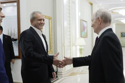 Ο Ιρανός πρόεδρος Μασούντ Πεζεσκιάν χαμογελά καθώς χαιρετά τον Βλαντιμίρ Πούτιν σε διάδρομο κτιρίου