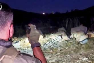 Ισραηλινός αστυνομικός με γάντια σε βραχώδη πλαγιά τη νύχτα κατά τη διάρκεια επιχείρησης