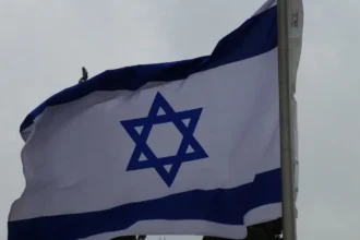 Ισραηλινή σημαία κυματίζει σε ιστό στην Ιερουσαλήμ με συννεφιασμένο ουρανό