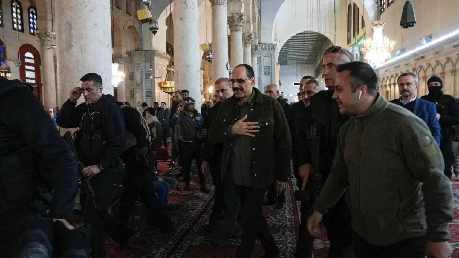 Ο Ιμπραχίμ Καλίν περπατά με συνοδεία μέσα στο τέμενος των Ομεϊαδών στη Δαμασκό