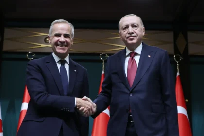 Ο Καναδός πρωθυπουργός Μαρκ Κάρνι και ο Τούρκος πρόεδρος Ρετζέπ Ταγίπ Ερντογάν δίνουν τα χέρια μπροστά σε καναδικές και τουρκικές σημαίες