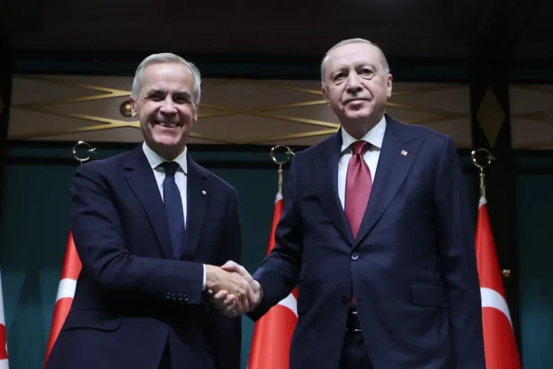 Ο Καναδός πρωθυπουργός Μαρκ Κάρνι και ο Τούρκος πρόεδρος Ρετζέπ Ταγίπ Ερντογάν δίνουν τα χέρια μπροστά σε καναδικές και τουρκικές σημαίες
