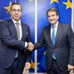 Ο Κύπριος υπουργός Εξωτερικών Κωνσταντίνος Κόμπος σφίγγει το χέρι του Ραφαέλε Φίτο μπροστά σε σημαίες της ΕΕ