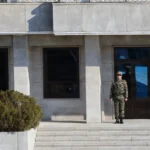 Βορειοκορεάτης στρατιώτης σε σκοπιά μπροστά από κτίριο στη βόρεια πλευρά της Αποστρατιωτικοποιημένης Ζώνης στο Πανμουντζόμ