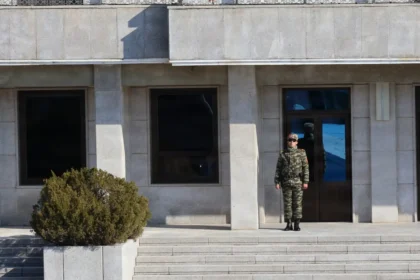 Βορειοκορεάτης στρατιώτης σε σκοπιά μπροστά από κτίριο στη βόρεια πλευρά της Αποστρατιωτικοποιημένης Ζώνης στο Πανμουντζόμ