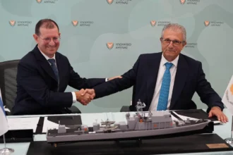 Χειραψία μετά την υπογραφή της συμφωνίας Κύπρου και Ισραήλ για νέο περιπολικό ανοικτής θαλάσσης, δίπλα σε μοντέλο πλοίου