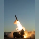 Εκτοξευτής HIMARS εκτοξεύει πύραυλο Precision Strike Missile με φλόγες και καπνό στο σούρουπο