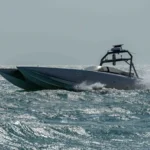 Γκρι μη επανδρωμένο ταχύπλοο σκάφος Devil Ray της MARTAC κινείται με ταχύτητα στη θάλασσα