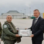 Ομάδα στρατιωτικών και πολιτικών μπροστά από τουρκικό F-16 σε υπόστεγο της αεροπορικής βάσης Λιελβάρντε