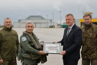 Ομάδα στρατιωτικών και πολιτικών μπροστά από τουρκικό F-16 σε υπόστεγο της αεροπορικής βάσης Λιελβάρντε