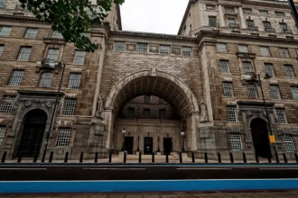 Η πρόσοψη του Thames House στο Millbank του Λονδίνου, με τη μεγάλη τοξωτή είσοδο ανάμεσα σε δύο πτέρυγες από πέτρα