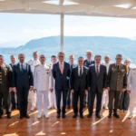 Ομαδική φωτογραφία στρατιωτικών και διπλωματών των αντιπροσωπειών Ελλάδας και Τουρκίας σε βεράντα με θέα στη θάλασσα στα Χανιά