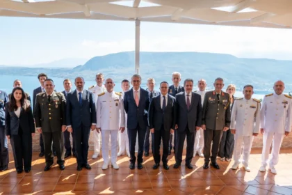 Ομαδική φωτογραφία στρατιωτικών και διπλωματών των αντιπροσωπειών Ελλάδας και Τουρκίας σε βεράντα με θέα στη θάλασσα στα Χανιά