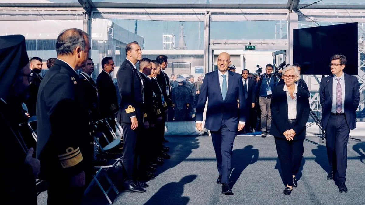 Ο Νίκος Δένδιας και η Κατρίν Βοτρέν περνούν μπροστά από αξιωματικούς του Πολεμικού Ναυτικού στην τελετή παράδοσης της φρεγάτας Νέαρχος στη Λοριάν